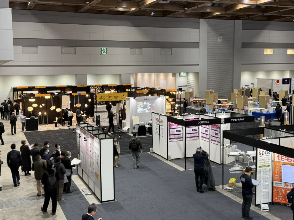 入口のエスカレーターで降りていくと正面奥に

"アカリ・イマージュ"コーナーのあたたかな灯りが見える。
コーナー右端がUMAGEが展示されているgram eightブース